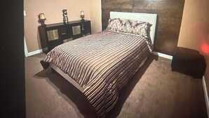 A bedroom with a bed, a ceiling fan, a nightstand, and a wall-mounted lamp. - FIFA Ready! Spacious 1800 sqf (Ellenwood)