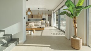 A modern living room with a staircase, a dining area, and a kitchen. - Villa Celest, a beautiful villa with fantastic views (Sellia)