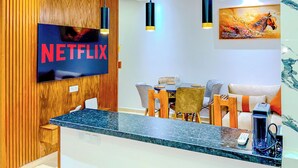 Moderni vastaanottoalue, jossa on Netflix-logo, marmorinen palvelutiski ja nykyaikaiset huonekalut.