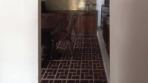 Un pasillo estrecho con suelo de baldosas que lleva a una zona de cocina.