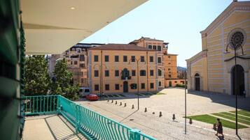 Un patio con barandilla verde, un edificio con cúpula e iglesia con cruz.