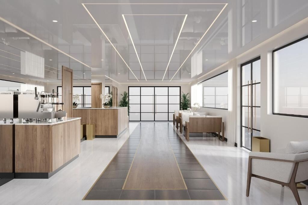 Een moderne keuken met een centraal eiland, een zithoek met een bank en tafel, en grote ramen die zorgen voor veel daglicht.