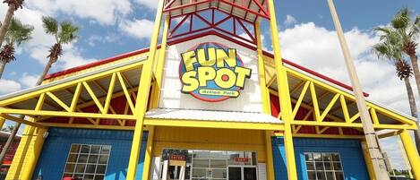 Un edificio con un letrero que dice "Fun Spot Action Park" y dos puertas señalizadas como "ENTRADA" y "SALIDA".