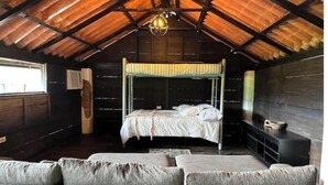 Habitación con literas, techo de madera y lámpara colgante.
