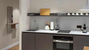 A modern kitchen with a built-in dishwasher, a kettle, and a coffee machine. - Apartment 7 Lemon (Lüneburg)