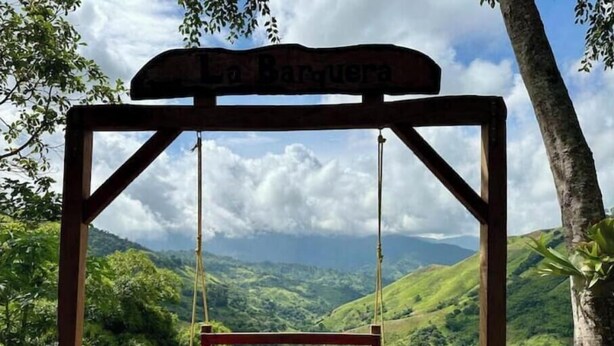 Ein Holzschaukelstuhl mit einem Schild darüber, auf dem 'La Barquera' steht.