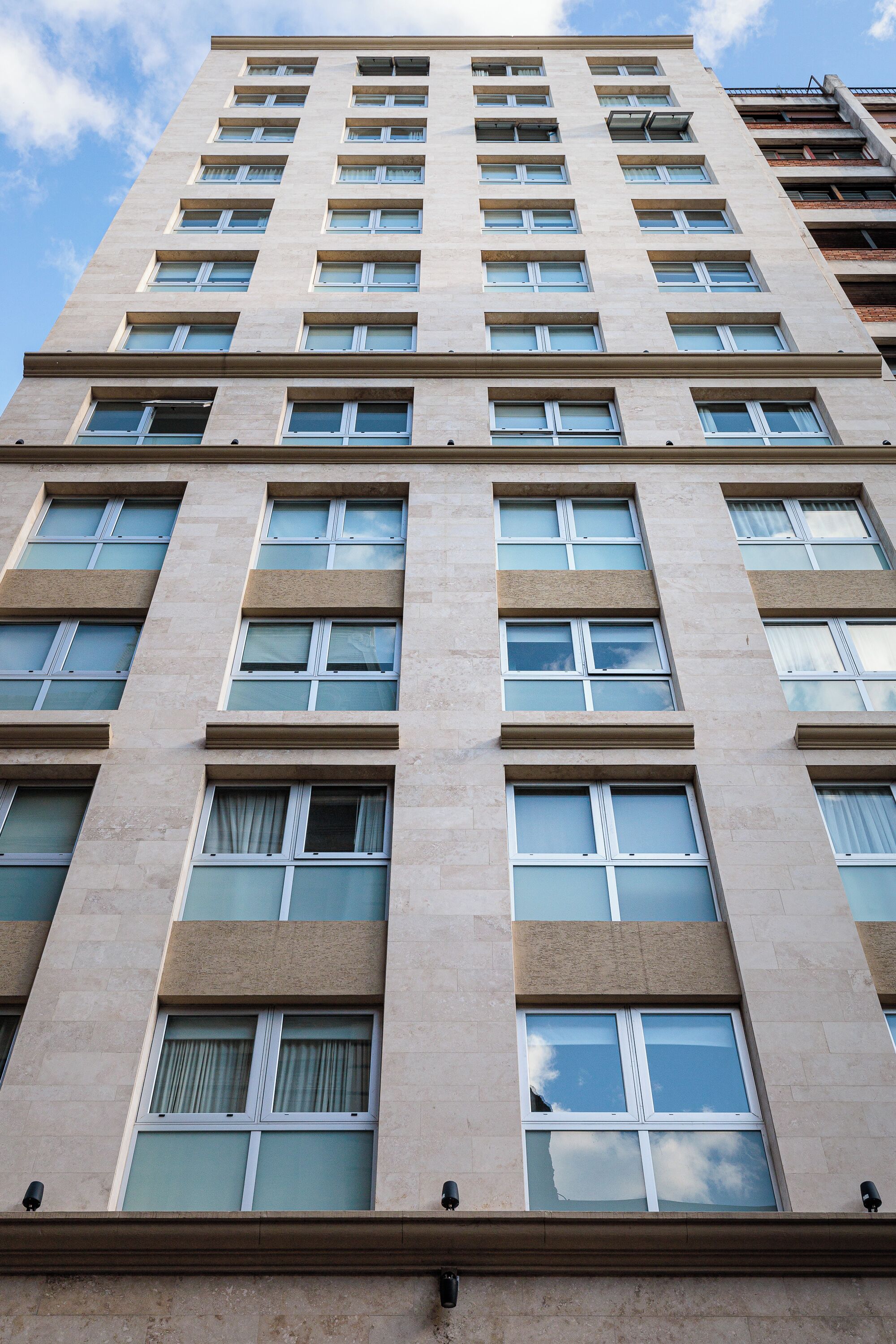 A high-rise building with multiple floors and rectangular windows.