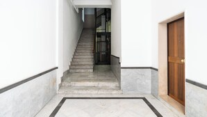 A staircase leading to a door, with a tiled floor and a white wall. - Umbertina Cozy Apartment by Wonderful Italy (Bari)