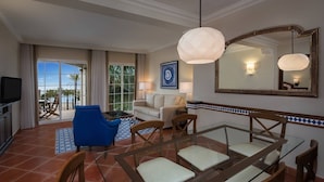 Une chambre d’hôtel comprenant un coin repas, un canapé, une télévision et une vue sur l’extérieur.