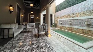 A covered outdoor area with a pool, patterned flooring, and seating. - Casa Agape in Downtown Mérida (Mérida)