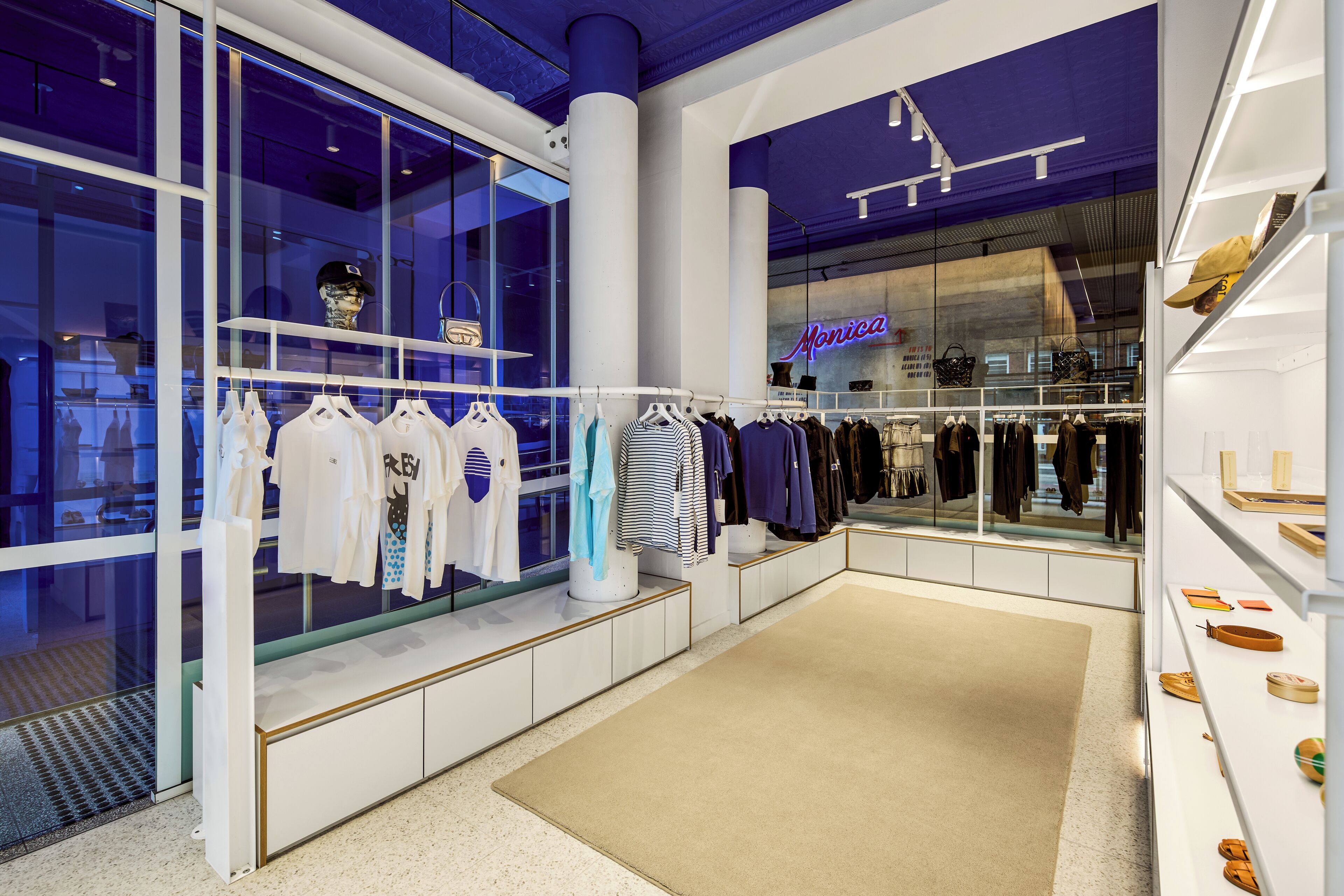 A modern retail space with clothing displays and a visible store named 'Monica'.