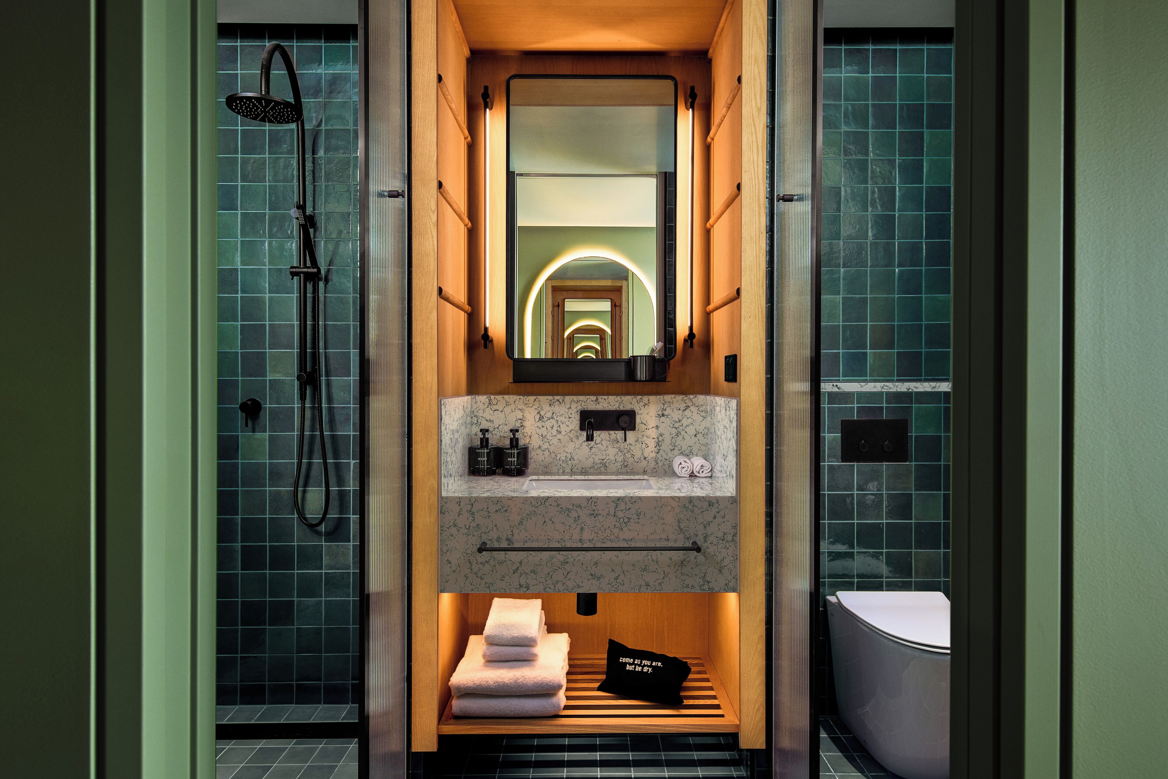 Une petite salle de bain comprenant une douche, un lavabo, un miroir et des toilettes.