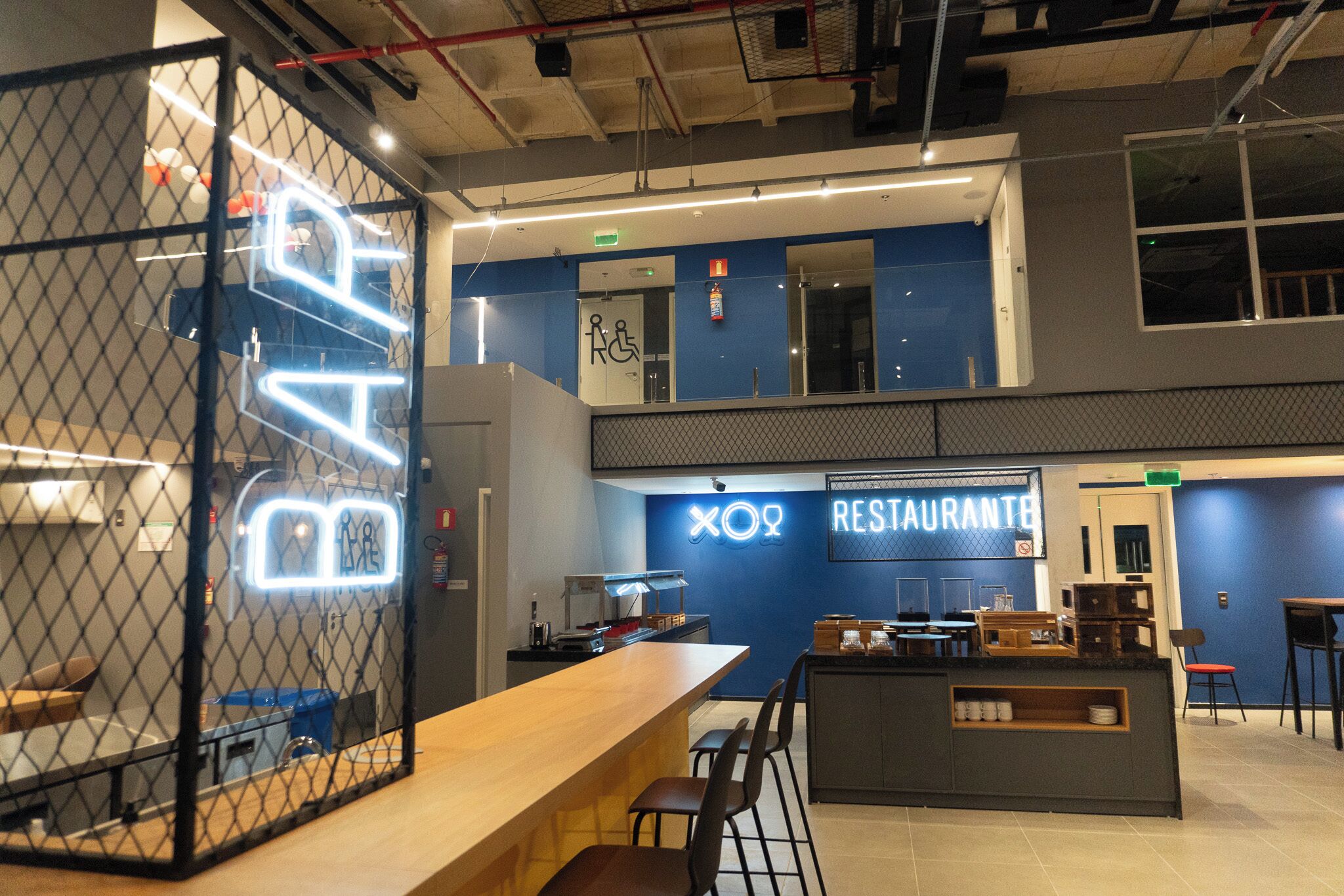 A modern interior with a bar area, a restaurant sign, and a wheelchair-accessible restroom.