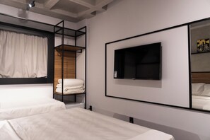 A modern hotel room with bunk beds, a flat-screen TV, and a large mirror. - Ibis Arcoverde (Arcoverde)
