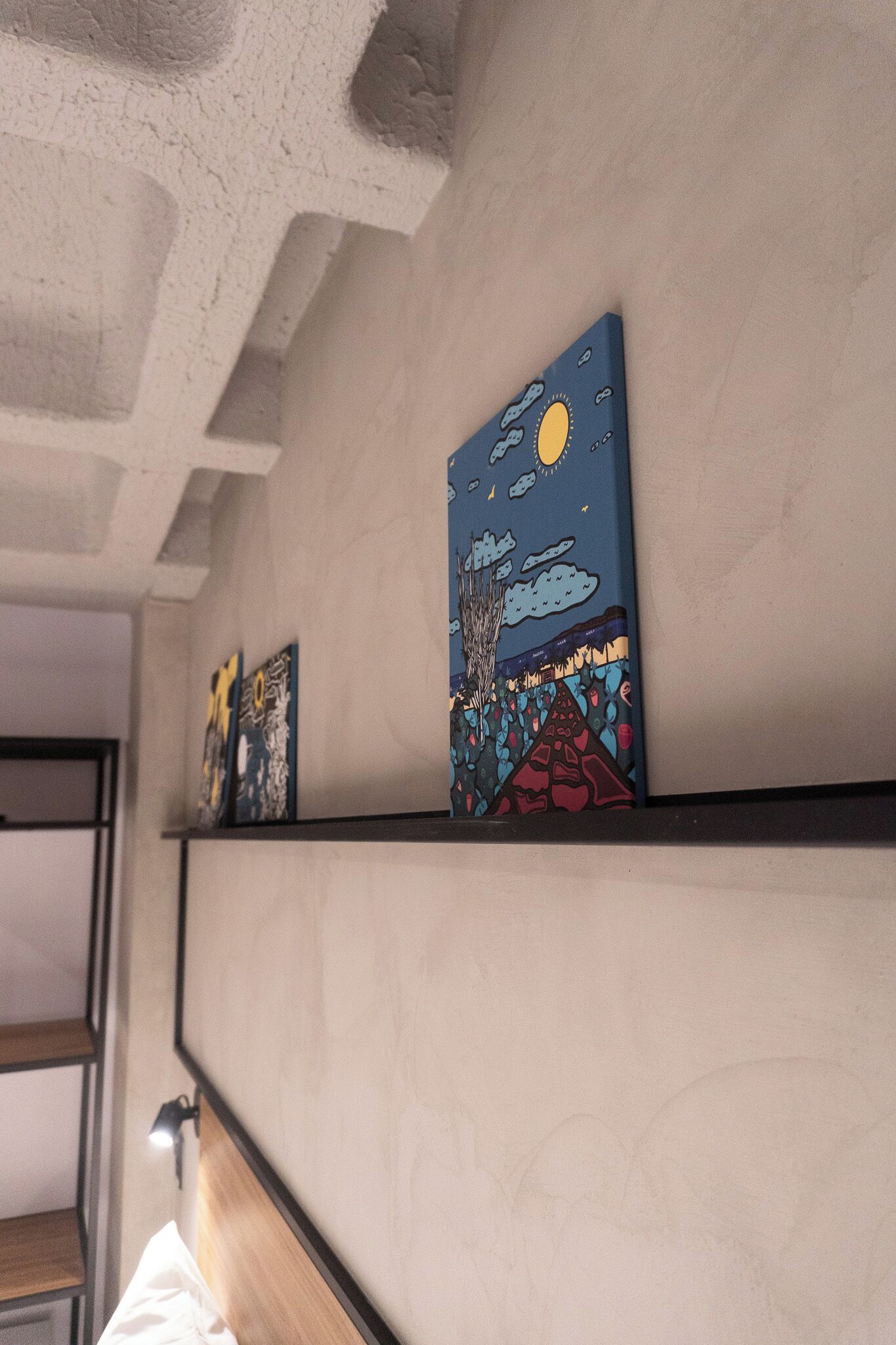 Artwork on a wall, a bed, and a staircase.