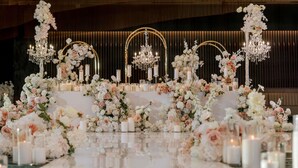 A luxurious reception area with a reflective marble floor, elegant floral arrangements, and ornate chandeliers. - Novotel Sydney Cabramatta (Canley Vale)