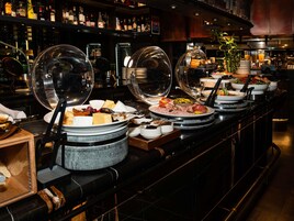 Montaje de bufé con diversos alimentos y una selección de bebidas.