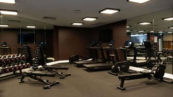 Ein Fitnessstudio mit Laufbändern, Kurzhanteln und Kraftgeräten.