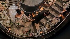 A wedding ceremony on a curved staircase with floral decorations and candles. - Novotel Sydney Cabramatta (Canley Vale)