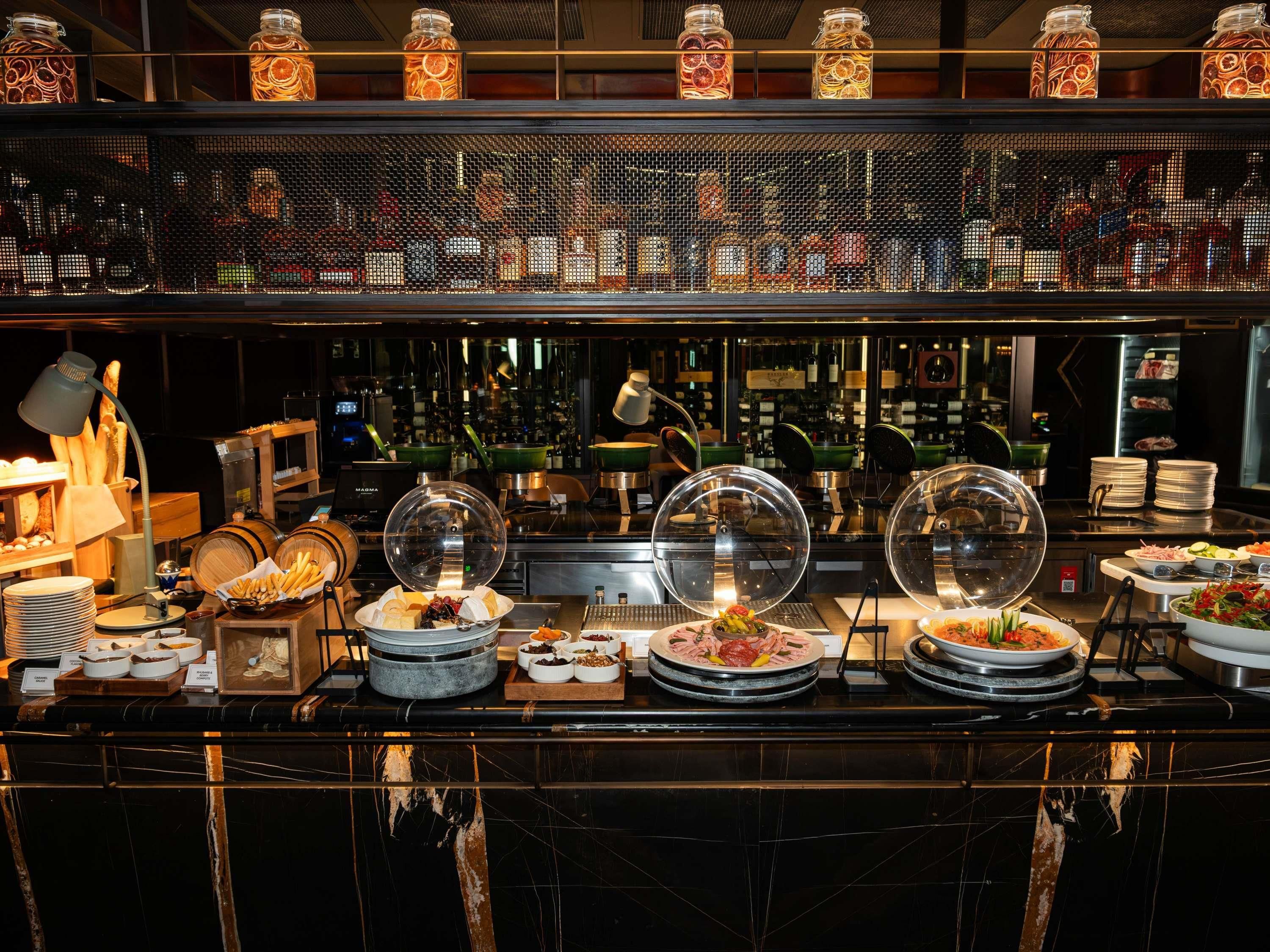 A buffet area with various food items, a coffee station, and a display of glass jars.