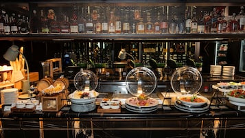 A buffet area with various food items, a coffee station, and a display of glass jars.