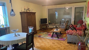 Un salon confortable avec une table à manger, des chaises, un canapé et un téléviseur.
