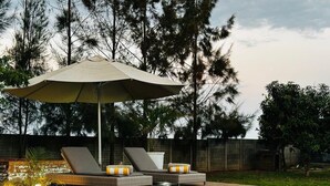 Une piscine avec deux chaises longues et un grand parasol.
