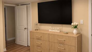 A bedroom with a bed, a dresser, a flat-screen TV, and a door.