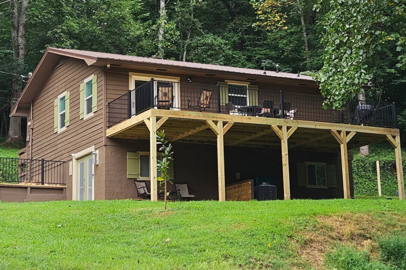 A two-story house with a covered porch and a fenced yard.