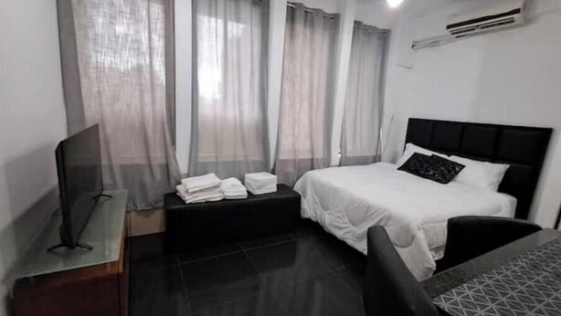 A hotel room with a bed, a TV, a desk, and a chair. - Suite in San Miguel Steps from Monagas Plaza (Monagas)