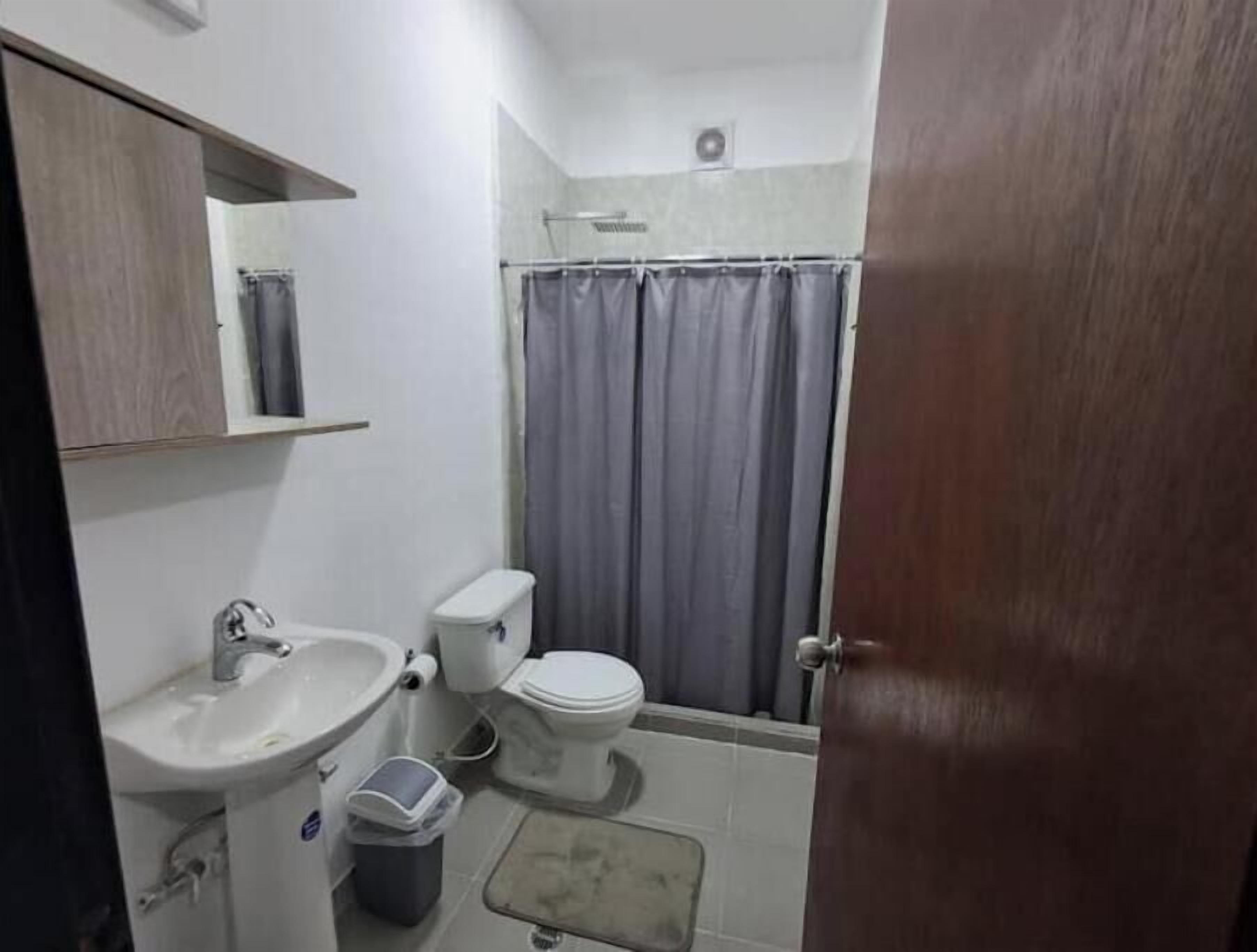 Een badkamer met een wastafel, toilet en douchegordijn.
