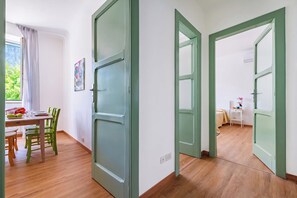A room with a dining area, a bed, and a small table with a potted plant. - L' Ali Apartment Near Noci old Town (Noci)