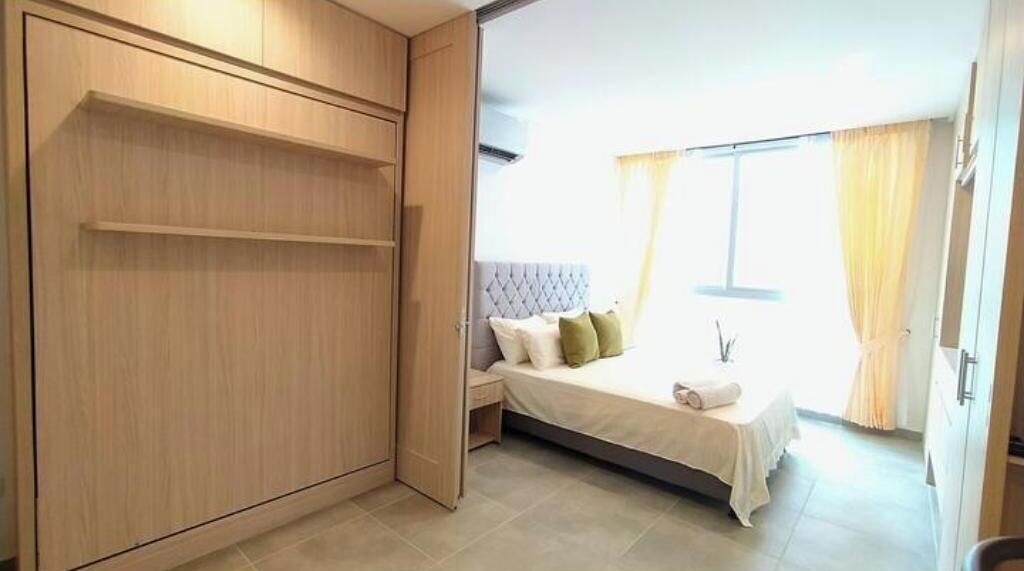 A bedroom with a bed, a nightstand, and a wardrobe.