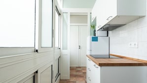 Une cuisine moderne avec des meubles blancs, un plan de travail en bois et une cuisinière intégrée.