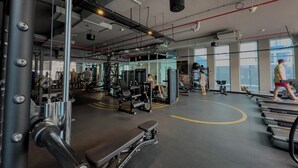 Ein Fitnessstudio mit unterschiedlichen Trainingsgeräten, Laufbändern und Kraftmaschinen.