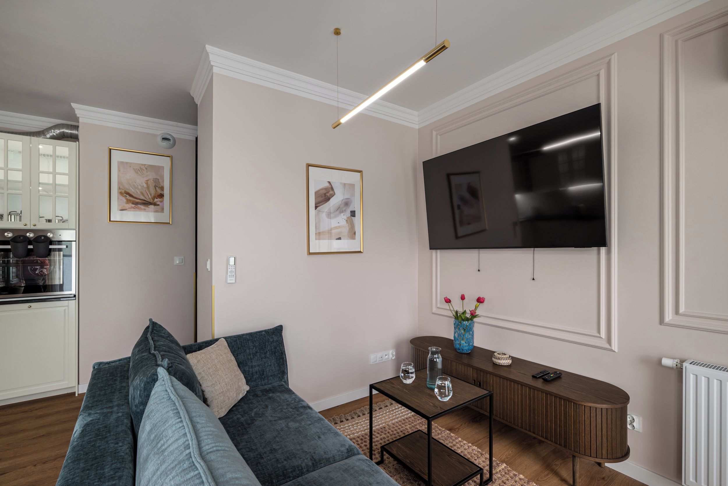 Una sala de estar moderna con un sofá, una mesa de centro y un televisor de pantalla plana montado en la pared.