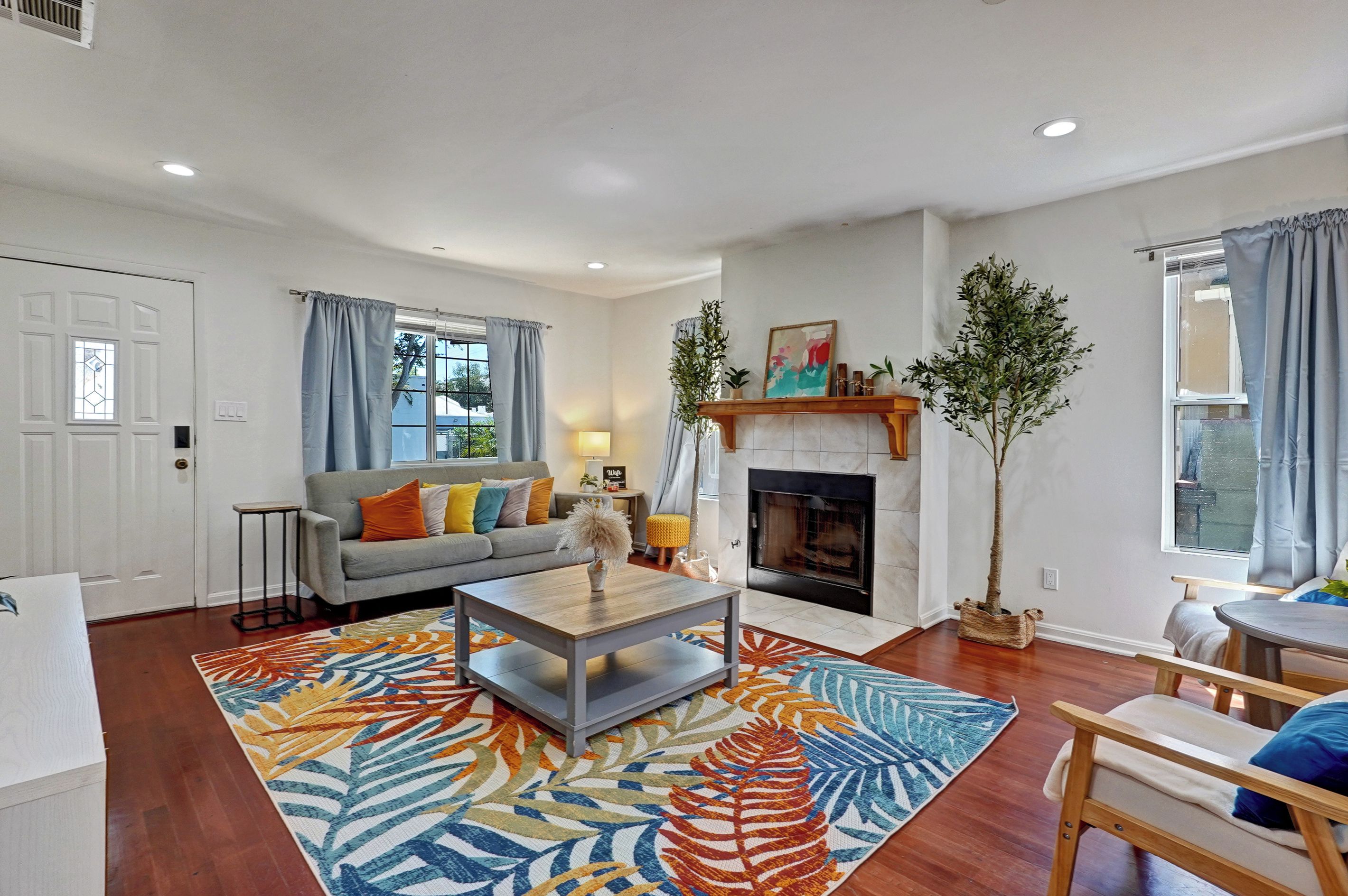 A living room with a fireplace, a sofa, a coffee table, and a patterned rug.