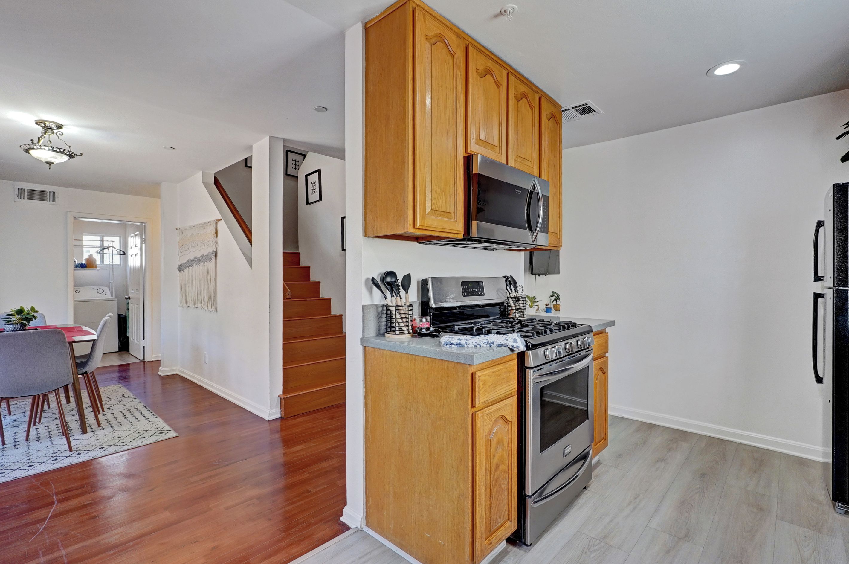Eine Küche mit Holzausstattung, einem Edelstahlherd und einer Mikrowelle.