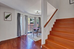 A staircase leading to a second floor, a dining area with a table and chairs, and a view of the outside through a glass door. - 4BR by Amazon & Sony Studios | Walk to Downtown (Culver City)