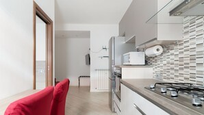 A modern kitchen with a gas stove, microwave, and refrigerator.