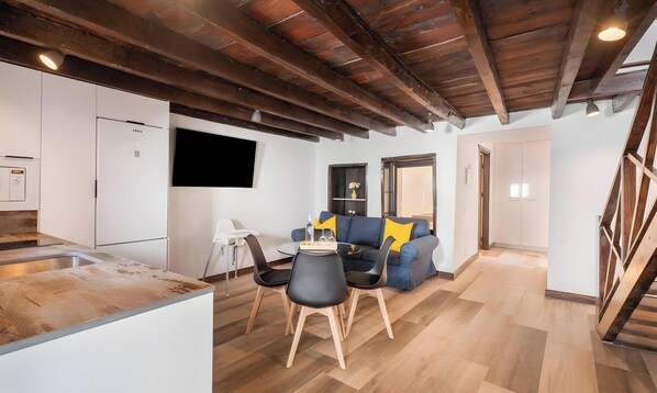 A modern kitchen with a built-in oven and a dining area with a table and chairs. - Vacation at 'Casa Miranda 3' with Private Terrace, Wi-Fi and Air Conditioning (Igueste de Candelaria)