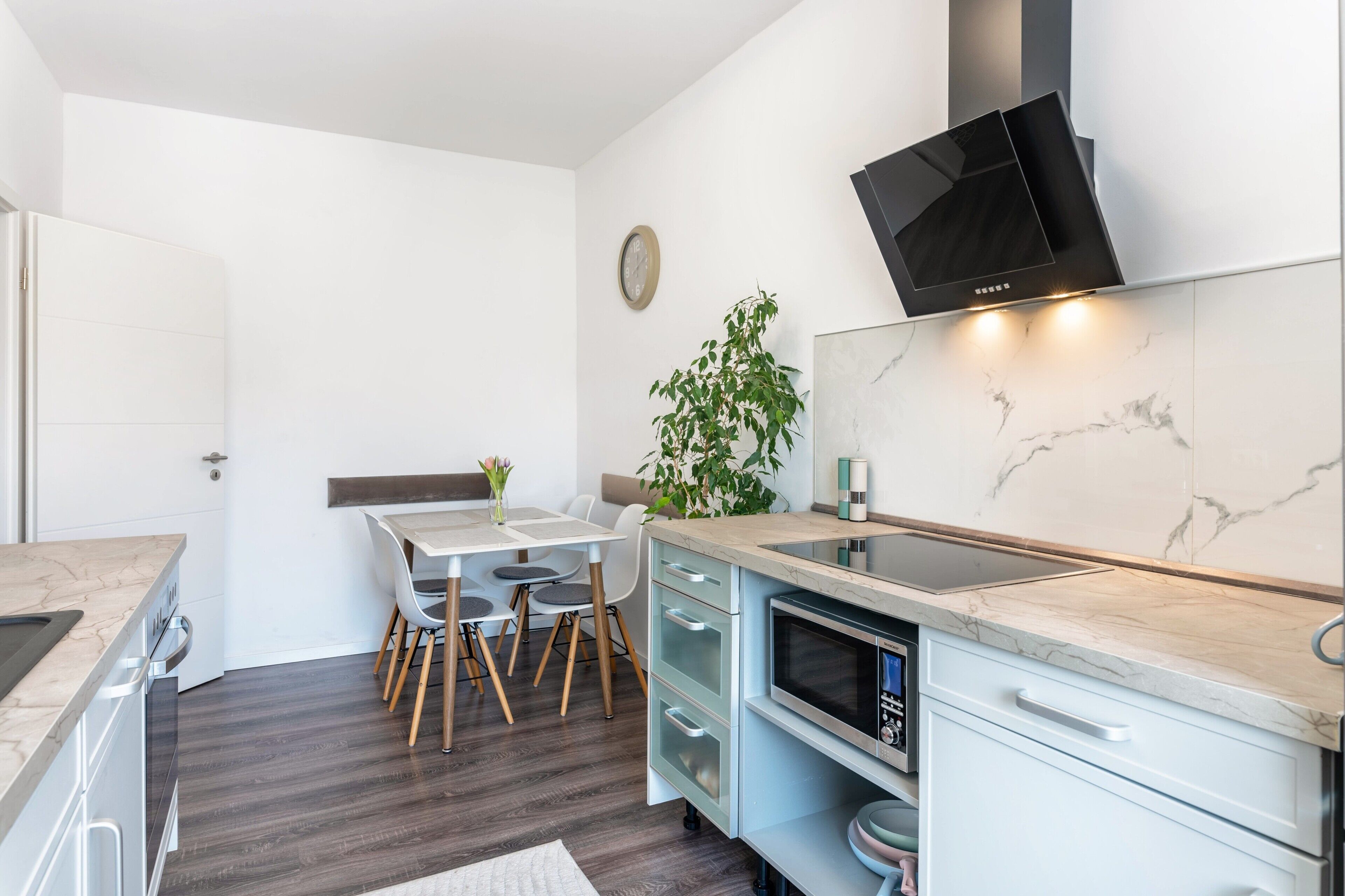 A compact kitchen with a built-in microwave, a stove, and a modern TV.