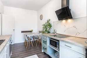 Una cocina compacta equipada con microondas, estufa y un televisor moderno.