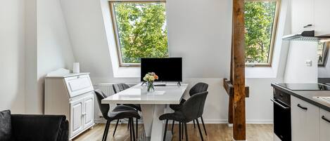 Una cocina moderna con una mesa de comedor, sillas y un ventanal grande.