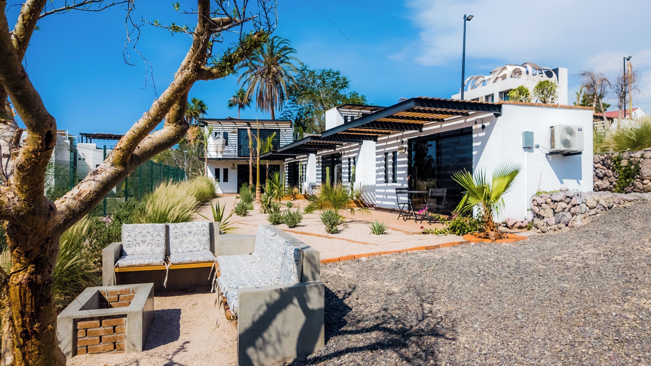 Et moderne hus med en patio, udendørs møbler og en swimmingpool.