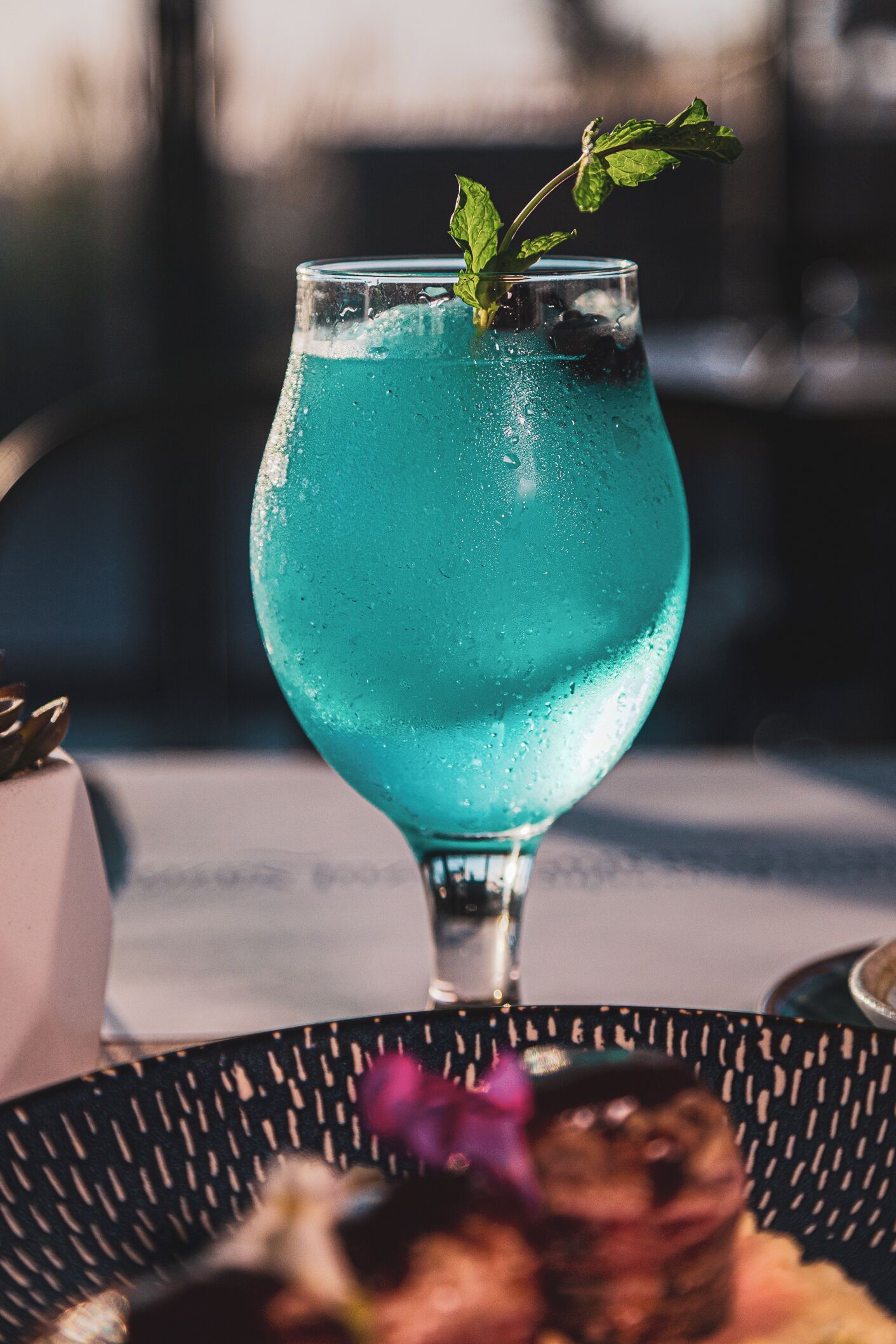 Een cocktailglas met munt op een tafel.