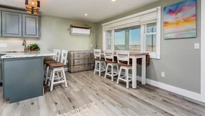 Una cocina con comedor, piso de madera y ventilador de techo.