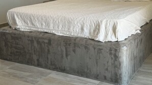 Une chambre à coucher avec un grand lit, une tête de lit et une table de chevet.