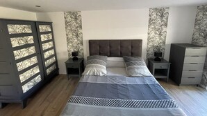 A bedroom with a large bed, two nightstands, a wardrobe, and a dresser. - Charming fully-equipped house (La Houssière)
