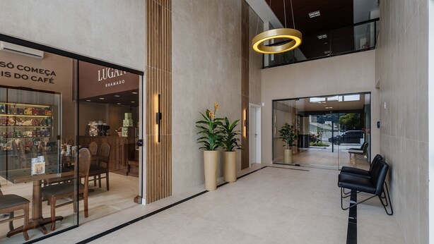 Un interior moderno con una cafetería, una zona de estar y una escalera.
